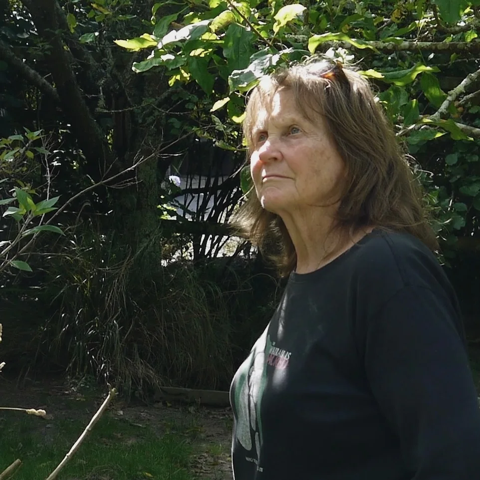 Pam standing in a leafy garden